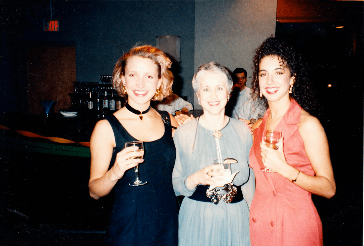 3 people pose for a photo at a party, holding drinks. The quality of the photos makes it look decades old